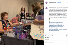 Angi Morgan hands a book to a fan